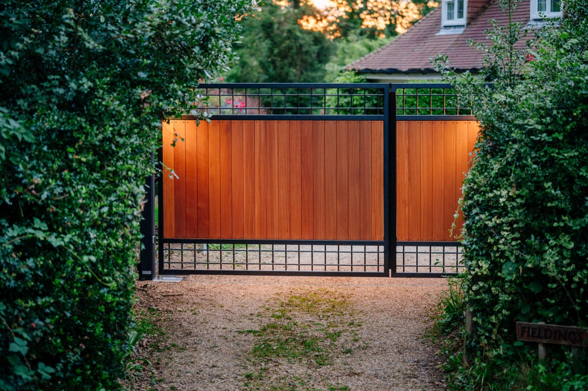 Made-to-measure timber driveway gates with a black steel frame, installed in Storrington, West Sussex
