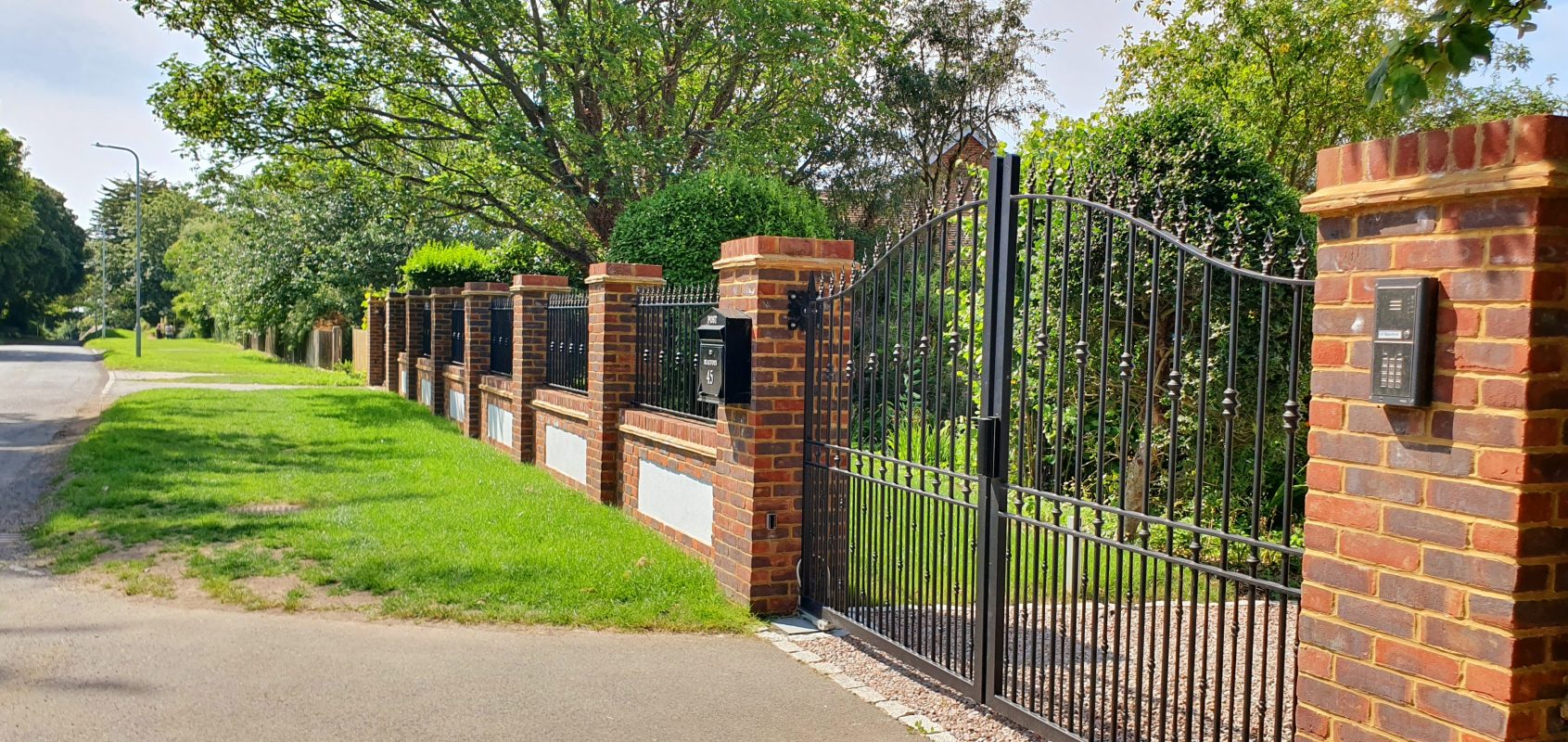 Tall electric driveway gates with a matching railing run