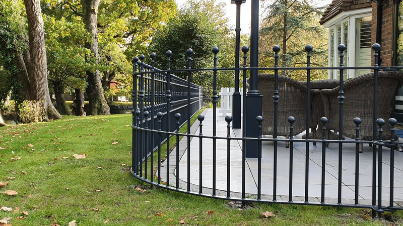 Bespoke metal garden railings around a paved terrace